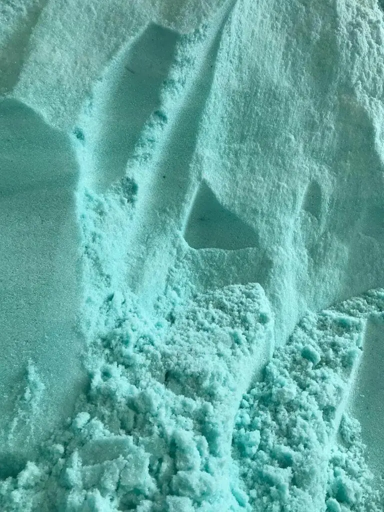 Green-blue ferrous sulfate heptahydrate crystals close-up powder texture